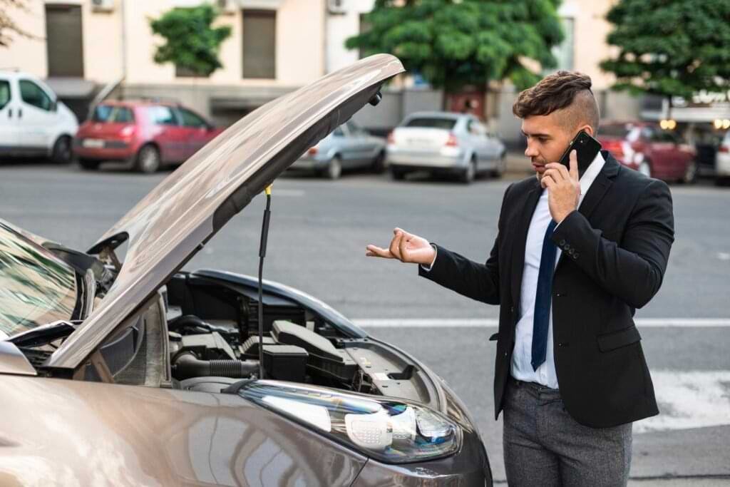 Man have a car problem and talking on phone